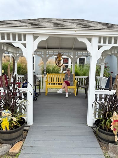 Resident sitting on a yellow bench in an outdoor gazebo