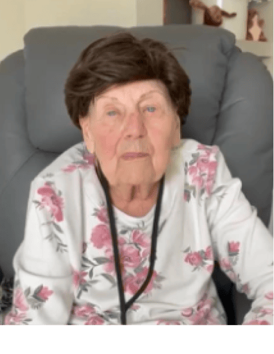 Elderly woman sitting in a chair, looking at the camera