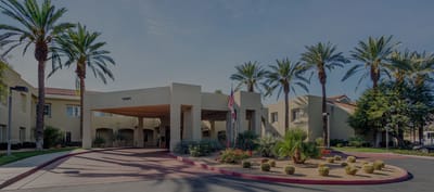 Entrance of a senior living facility with palm trees