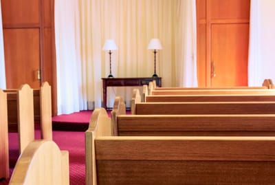 Chapel interior with wooden pews and lamps