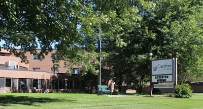 Exterior view of Carefree Living with green lawn and sign