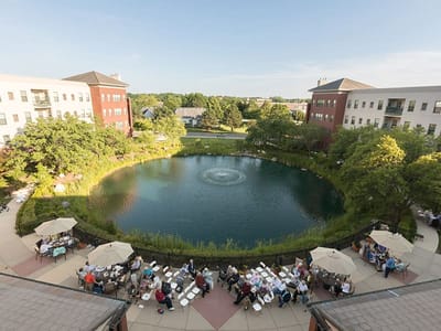 Aerial view of residents enjoying a peaceful outdoor space by a pond