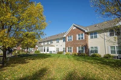 Outdoor view of Oak Terrace Assisted Living with trees and lawn