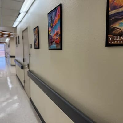 A hallway in a senior living facility with framed art