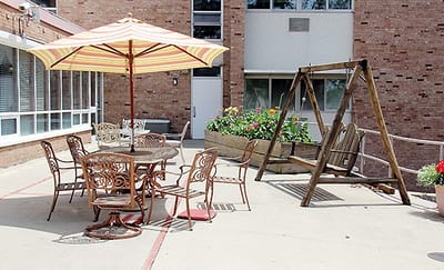 Outdoor seating area with tables and a swing set