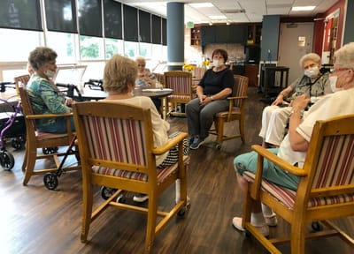 Residents engaged in conversation in an activity room