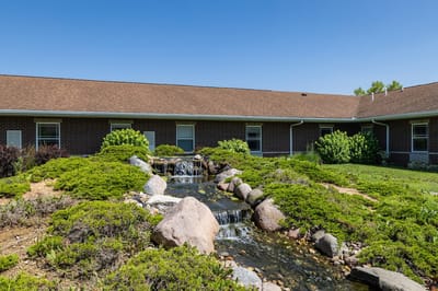 Outdoor space with a small waterfall and landscaping
