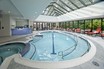 Indoor pool area with natural lighting and lounge chairs