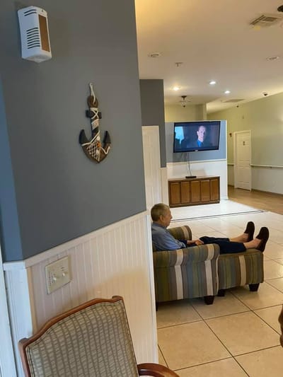 Resident watching TV in a lounge area