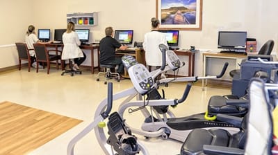 Therapy room with staff and residents using equipment