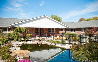 Exterior view of Arbor Grove Village with a landscaped pond