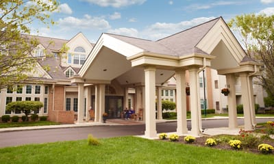 Entrance of Baldwin House Senior Living with residents sitting outside