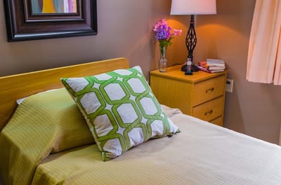 Cozy resident room with bed and lamp