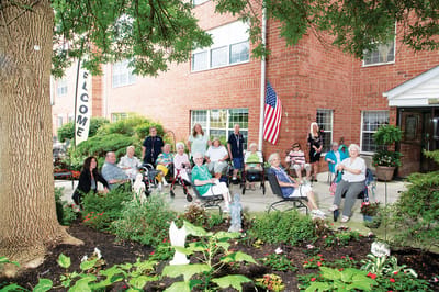 Residents enjoying an outdoor gathering near the facility entrance