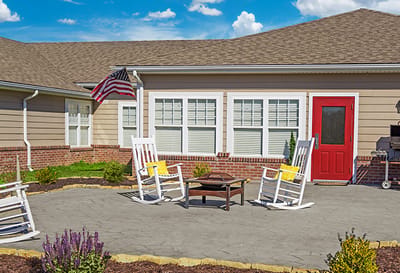 Outdoor seating area with rocking chairs and a red door