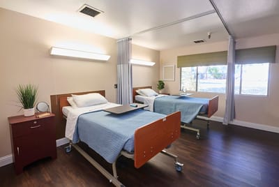 Two beds in a bright, well-furnished resident room