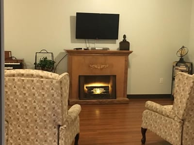 Indoor sitting area with chairs and a decorative fireplace