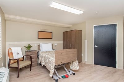 Private resident room with bed and chair