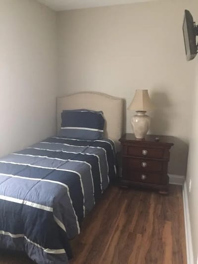 A cozy resident bedroom with a bed and lamp