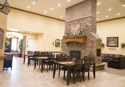 Bright common area with seating and a stone fireplace