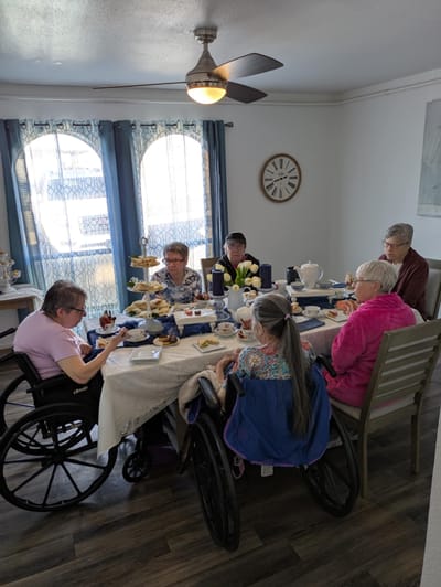 Residents enjoying tea and snacks at a dining table