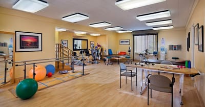 Physical therapy room with equipment and exercise mats