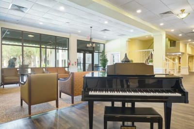 Piano in a bright lobby area with seating