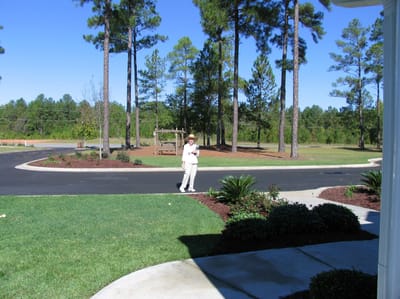 A resident walking in a landscaped outdoor area