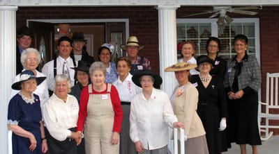 Residents and staff in vintage attire smiling together