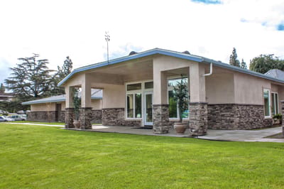 Exterior view of a senior living facility with greenery