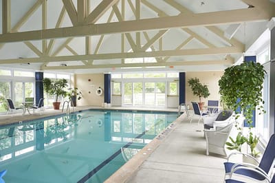 Indoor pool area with lounge chairs and large windows