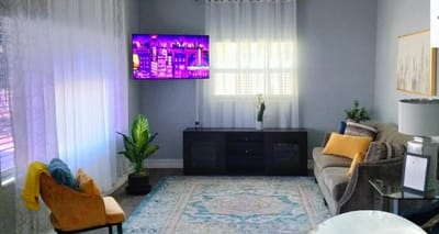Bright common area with a couch and TV