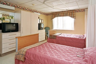 A shared resident room with two beds and furniture