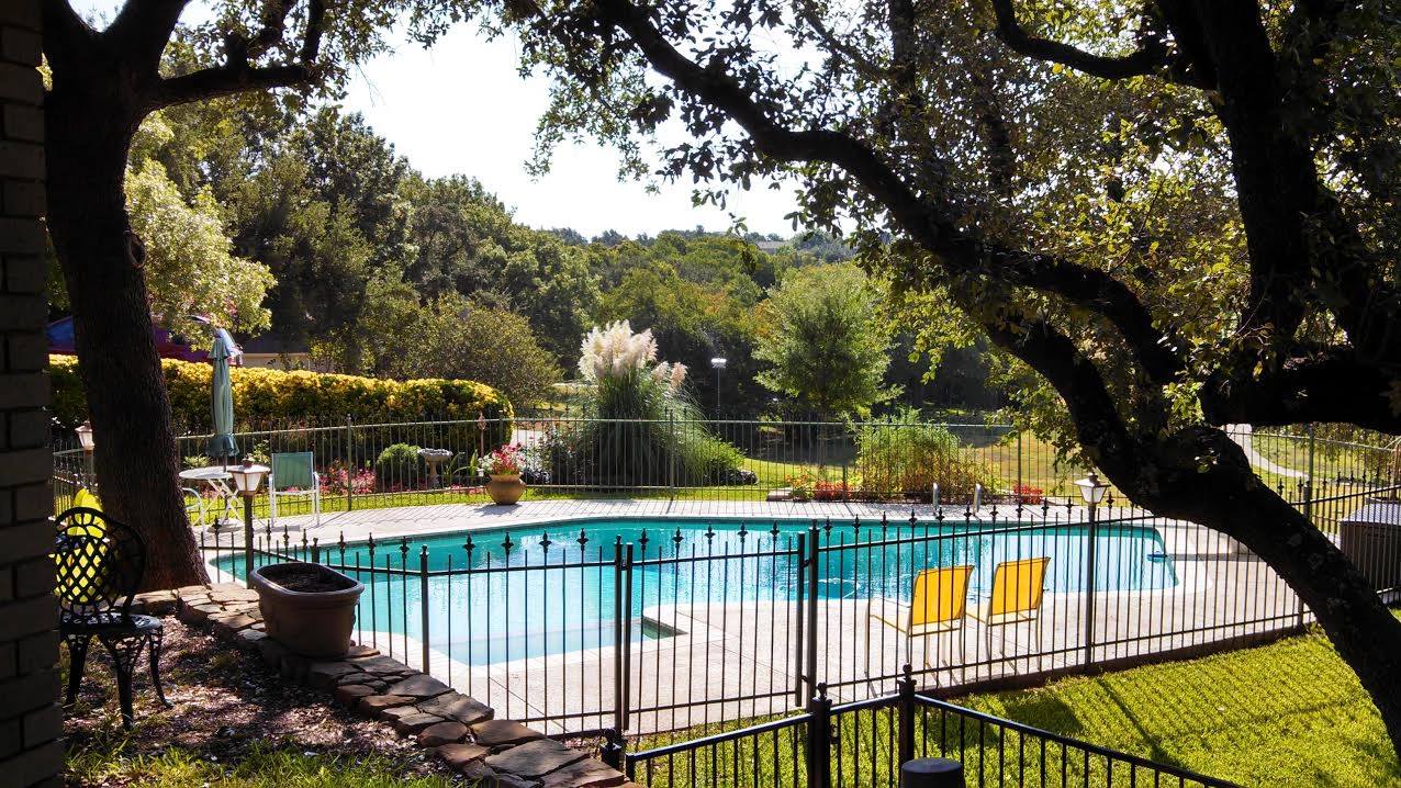Outdoor pool area with chairs and greenery