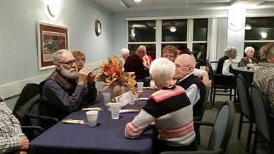 Residents gathered around tables in a common area