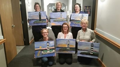 Staff and residents showcasing their artwork in a hallway