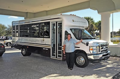 Facility transport vehicle with staff member
