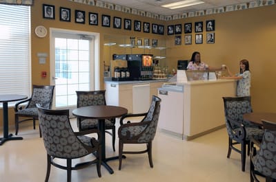 Two staff members serving at the facility's cafe area