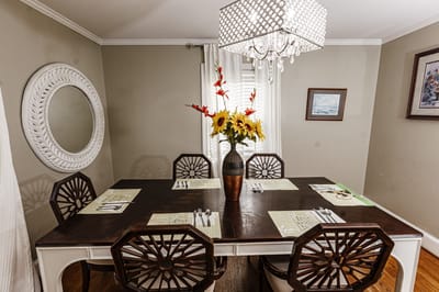 Elegant dining room with a large chandelier and flower arrangements