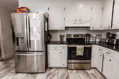 A view of a kitchen with appliances and cabinets