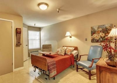 Brightly decorated resident room with bed and seating area
