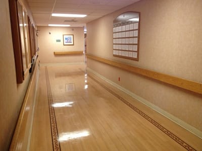 Well-lit hallway with wooden railings and framed pictures