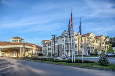 Exterior view of a senior living facility with flags