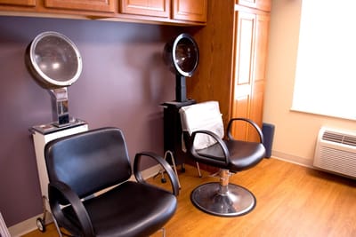 Hair salon area with styling chairs and hair dryers