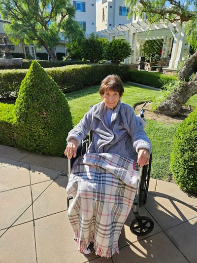 Resident enjoying the garden area in a wheelchair