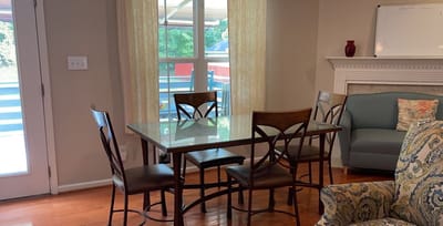 Brightly lit common area with a dining table and chairs