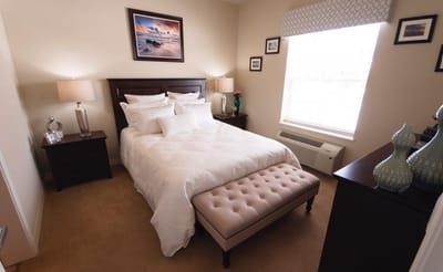 A well-decorated private resident room with a bed and artwork
