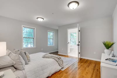 Bright, simple private resident room with bed and windows
