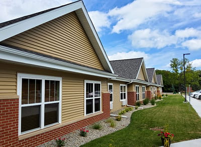 Exterior view of the senior living facility with gardens