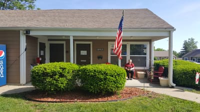 Entrance of Parkview Gardens Apartments with a resident outside